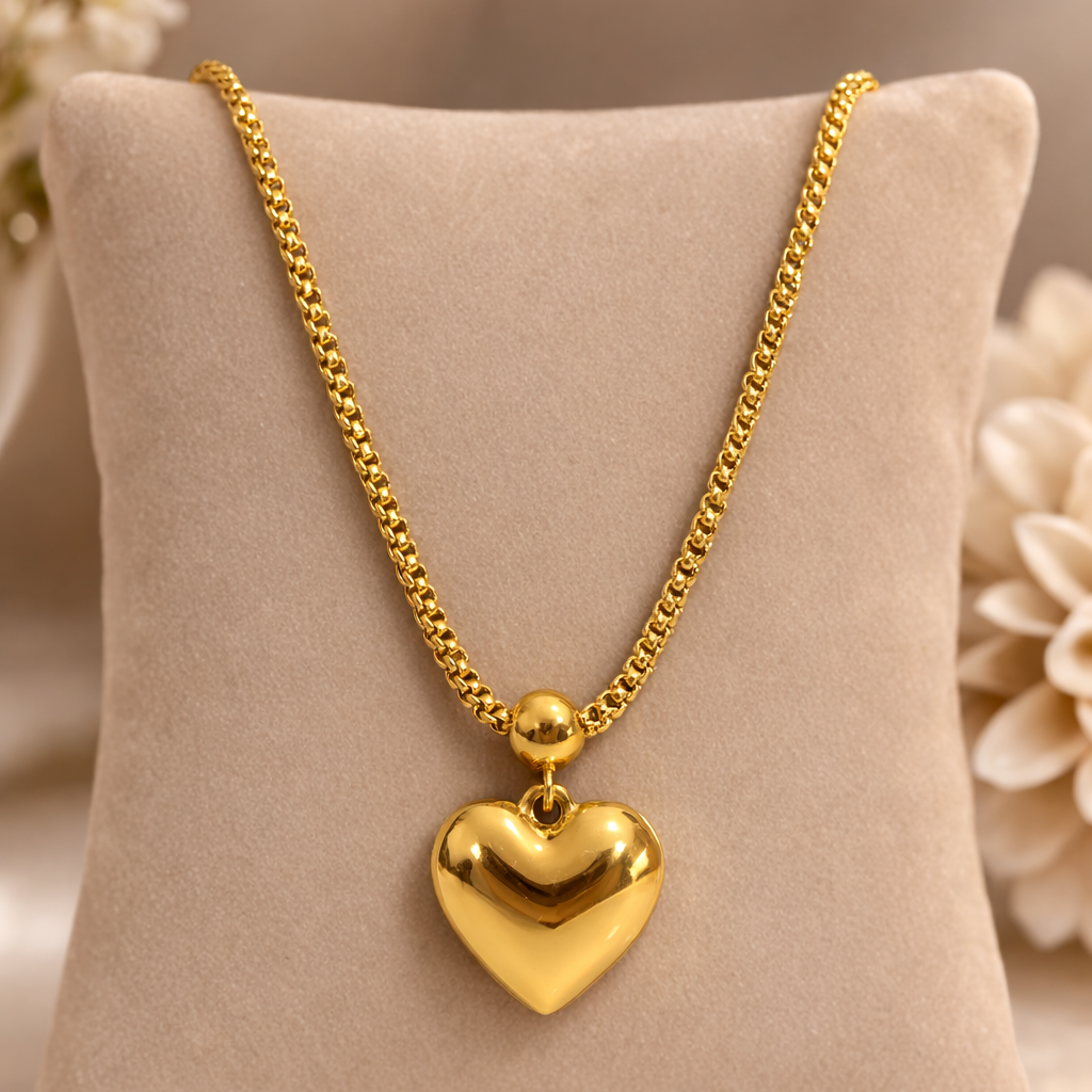Gold heart-shaped pendant necklace on a beige pillow with flowers in the background
