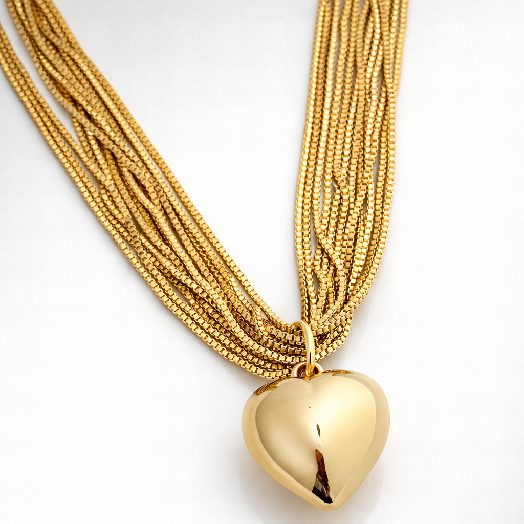 Gold necklace with a heart pendant on a white background