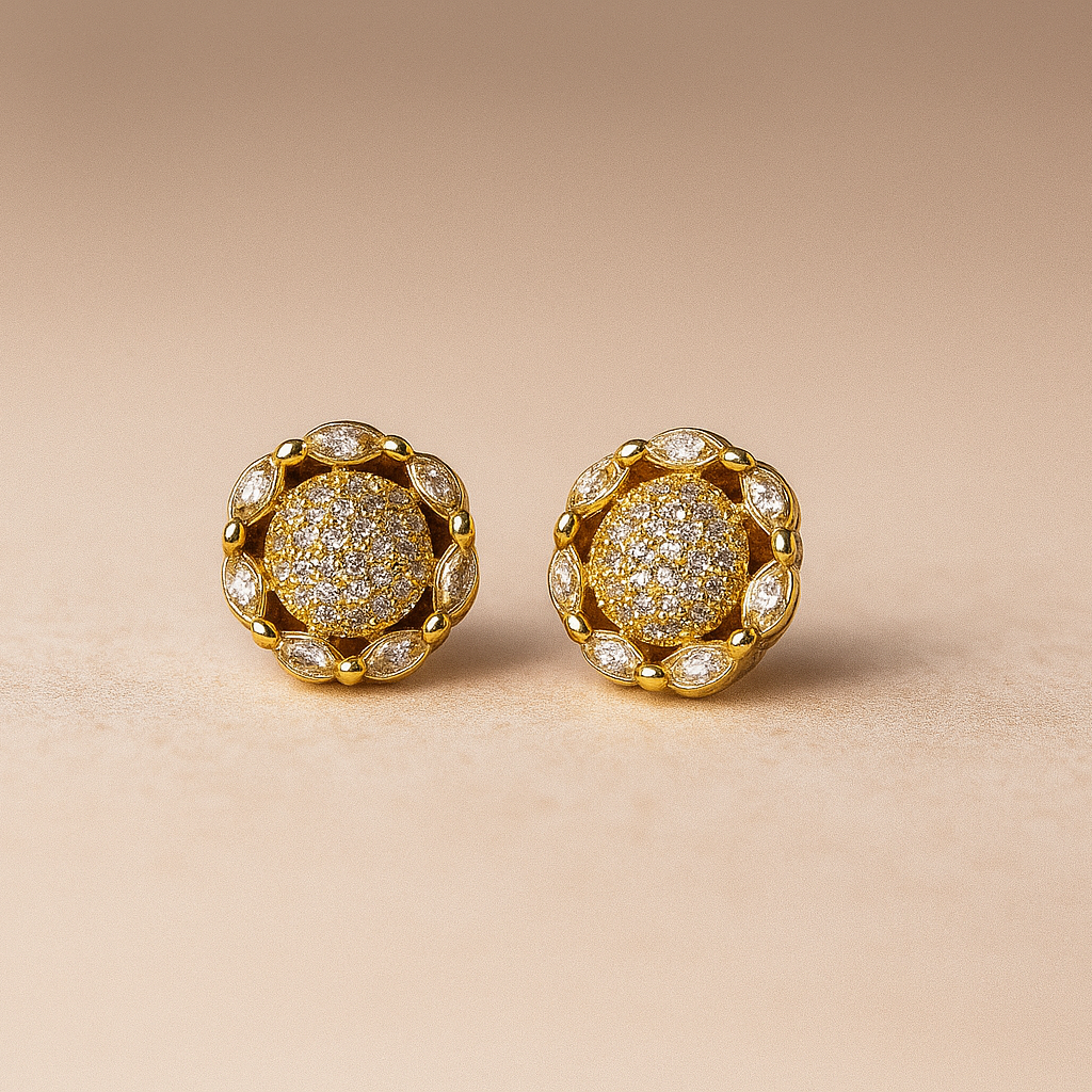 Pair of gold earrings with diamond-like stones on a beige background