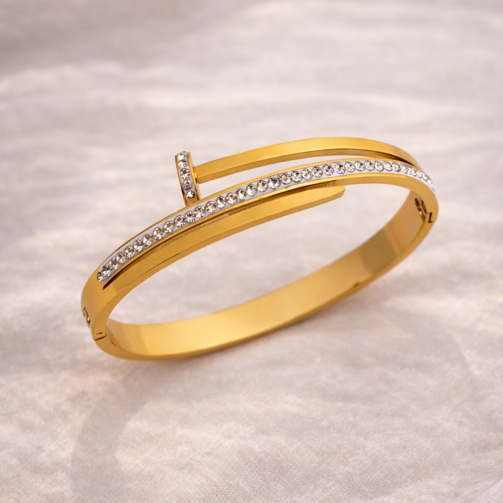 Gold bracelet with embedded diamonds on a soft fabric background