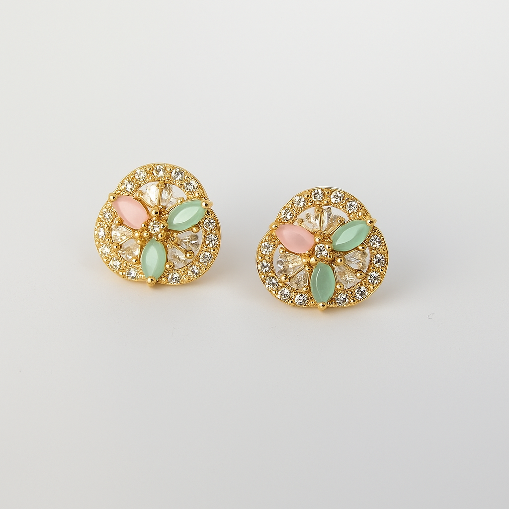 Pair of gold earrings with pastel green and pink stones on a light gray background