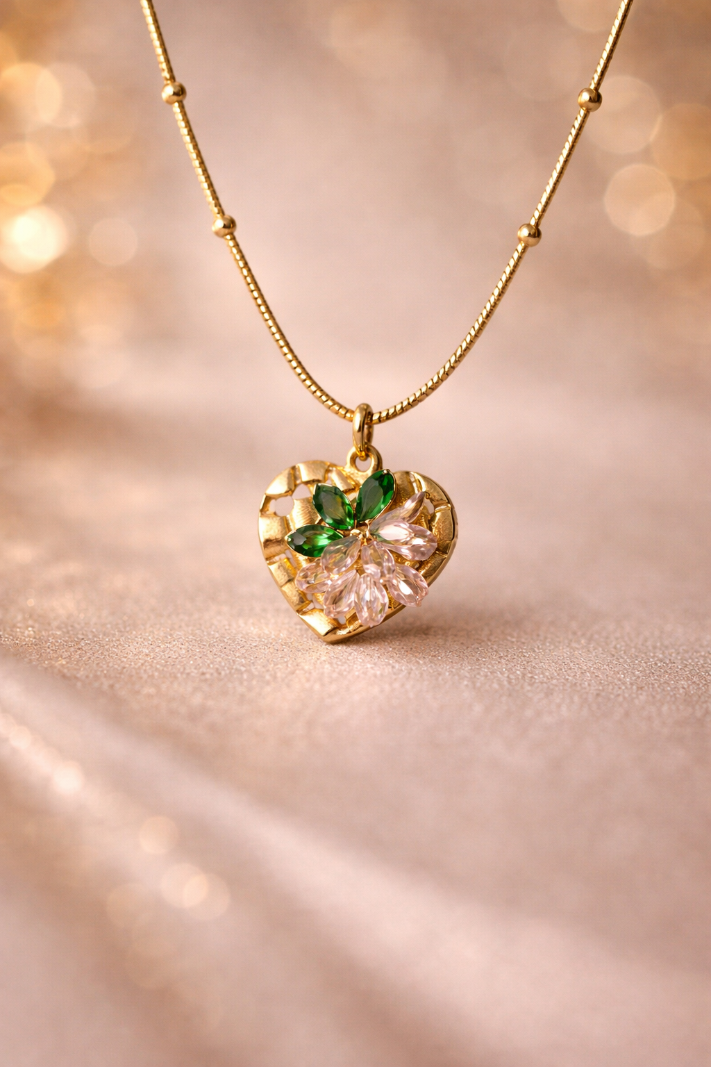 Gold necklace with a heart-shaped pendant on a soft, blurred background