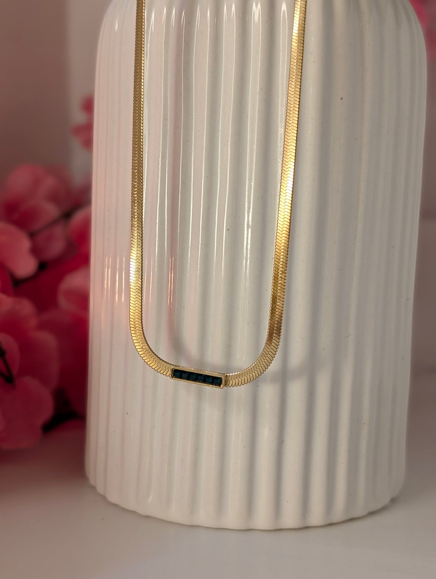 White ribbed vase with gold accent on a pink background