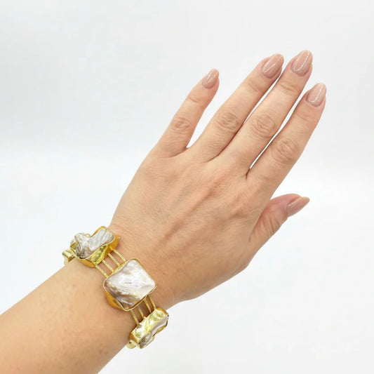 Hand wearing a bracelet with large beads on a white background