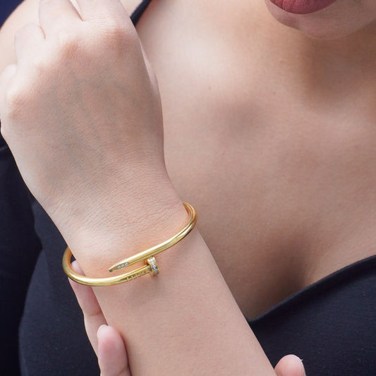 Gold bracelet on a person's wrist with a blurred background