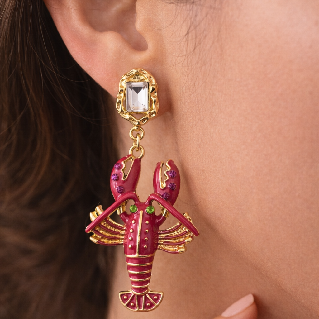 Lobster-shaped earring worn by a person with a blurred background