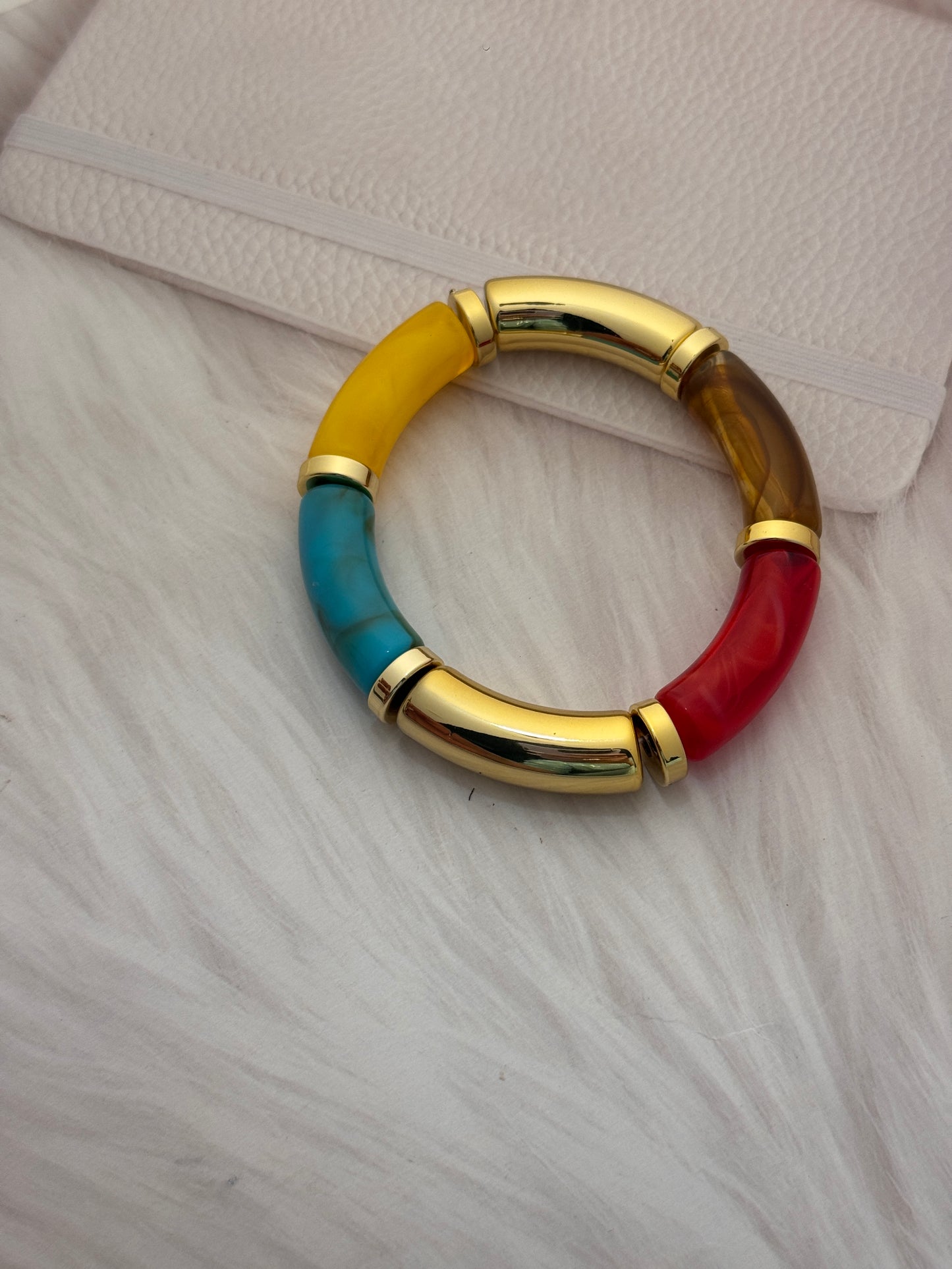 Multicolored ring with gold band on a textured surface