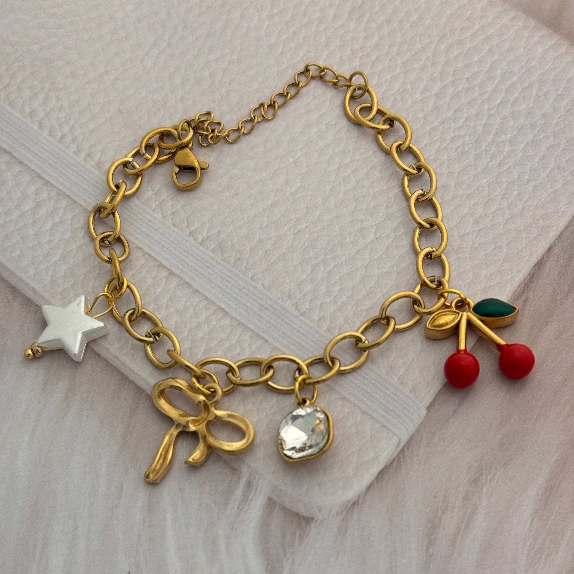 Gold bracelet with charms on a textured surface