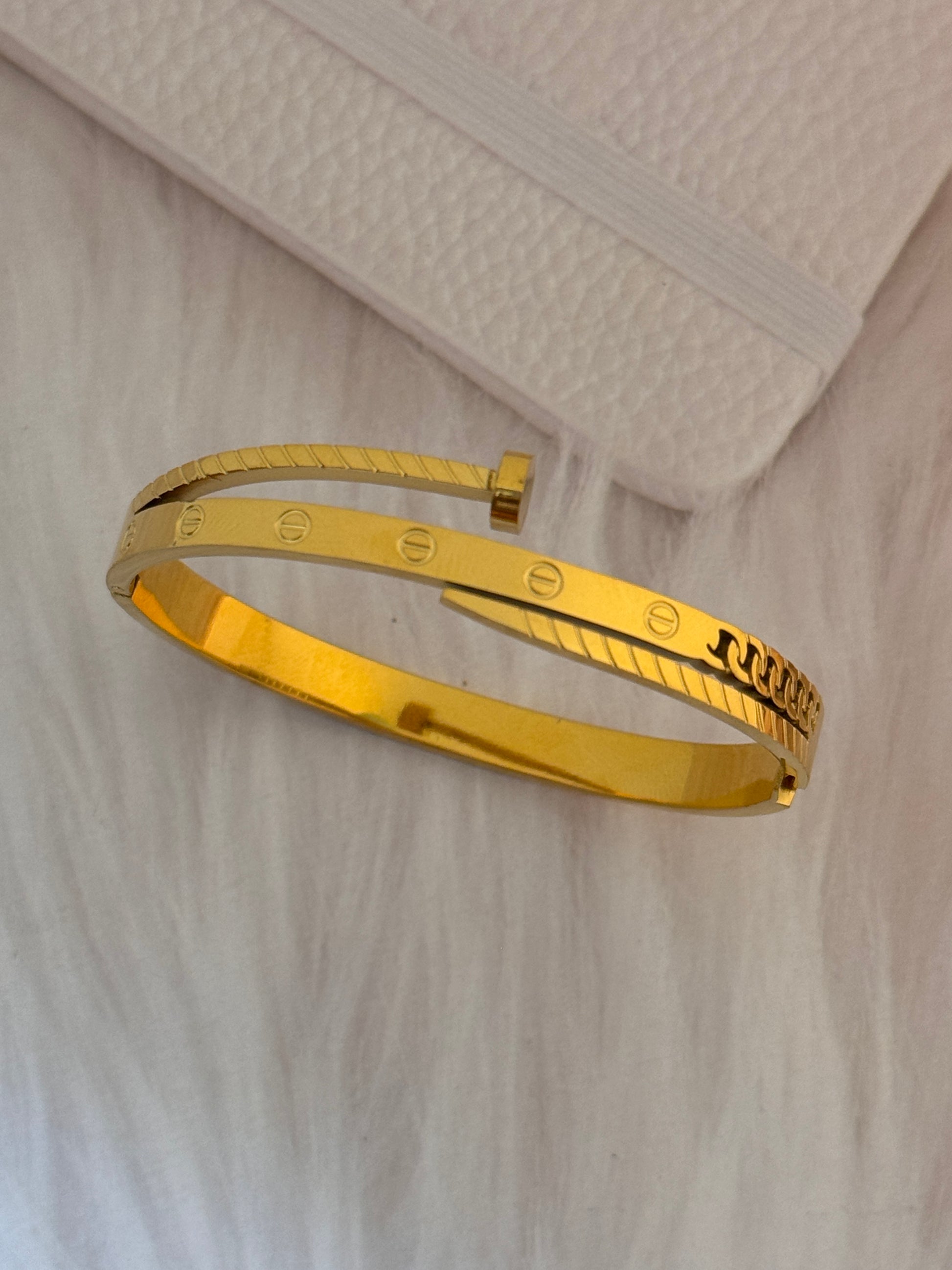 Gold bracelet on a textured beige surface