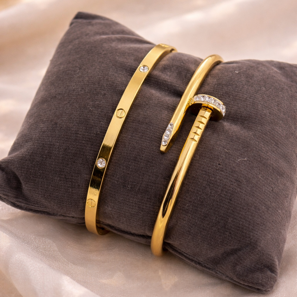 Gold bracelets with diamond accents on a gray pillow