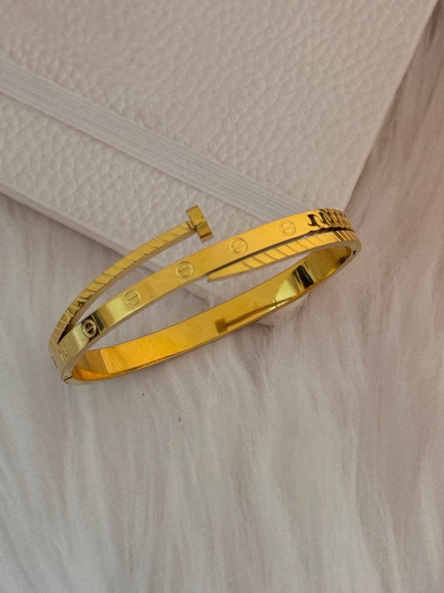 Gold bracelet on a textured white surface