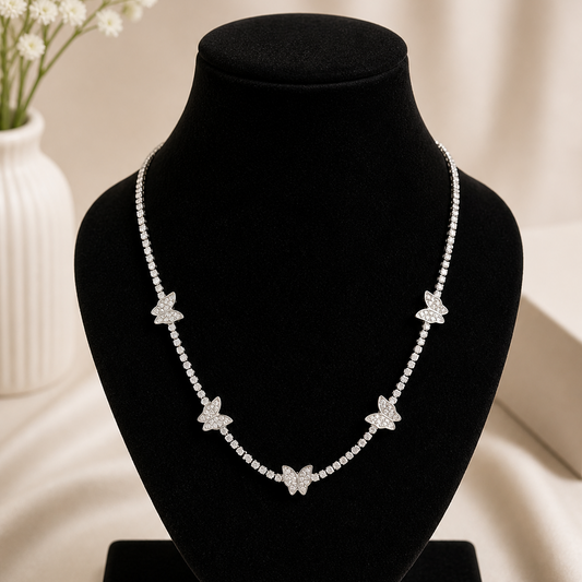 Necklace with butterfly pendants on a black velvet stand with a blurred background