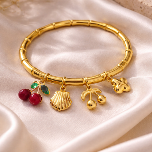 Gold bracelet with charms on a beige fabric background