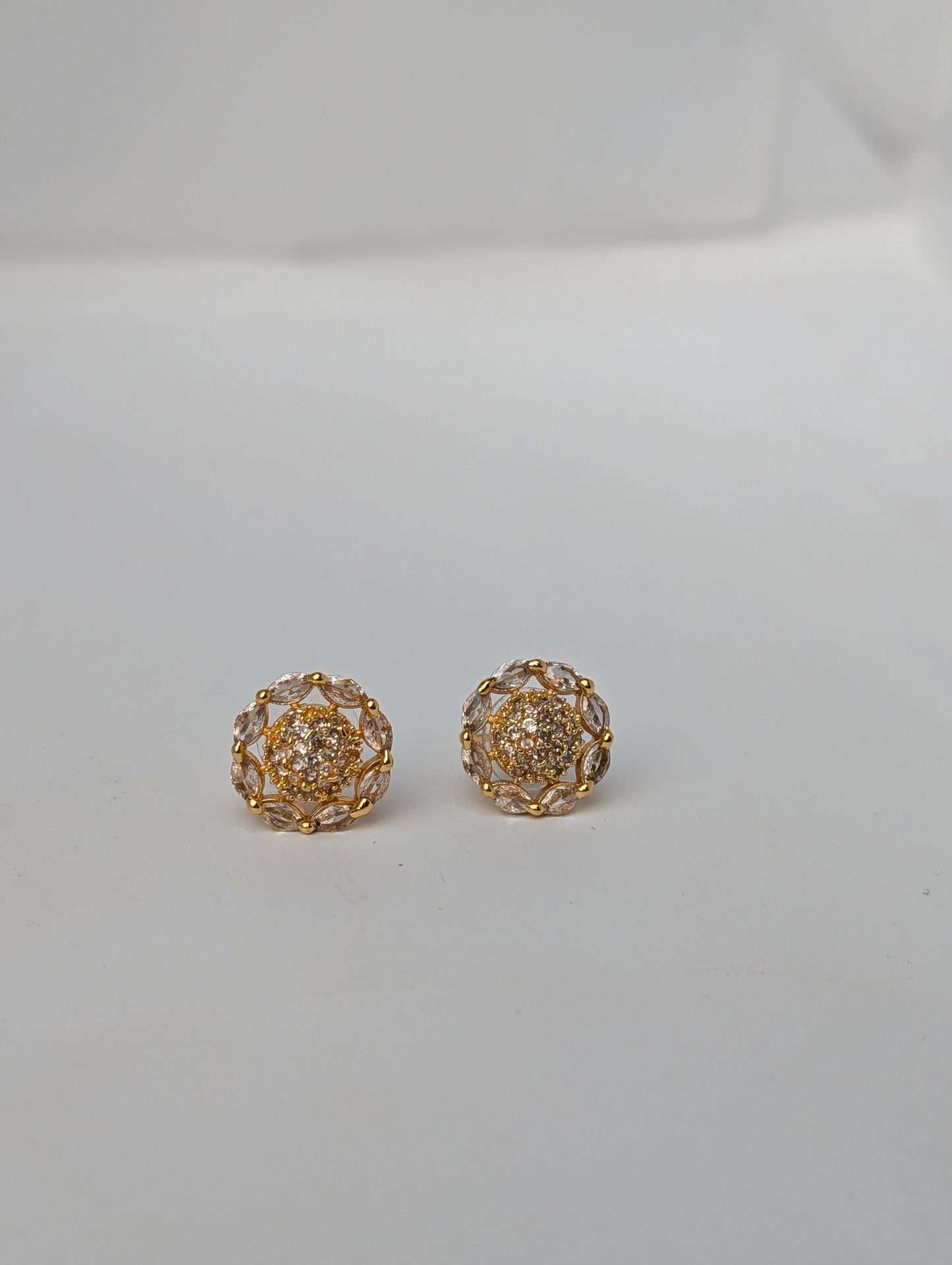 Pair of gold earrings on a light gray background
