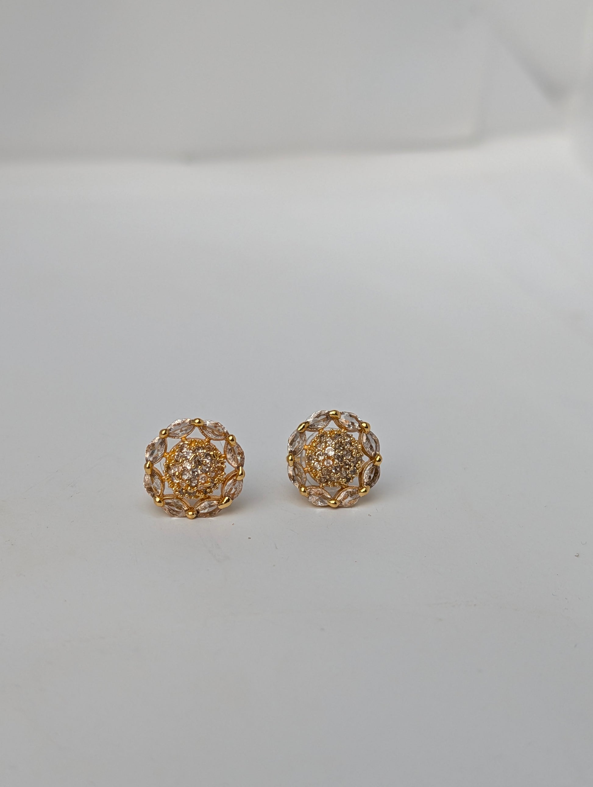 Pair of gold earrings on a light gray background