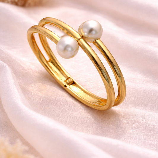 Gold bracelet with pearls on a soft fabric background