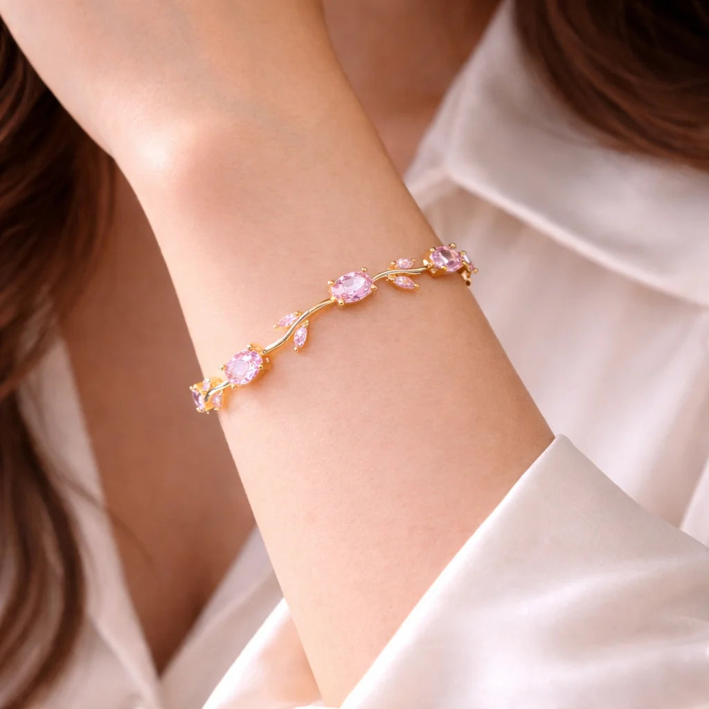 Bracelet with pink gemstones on a person's wrist against a neutral background