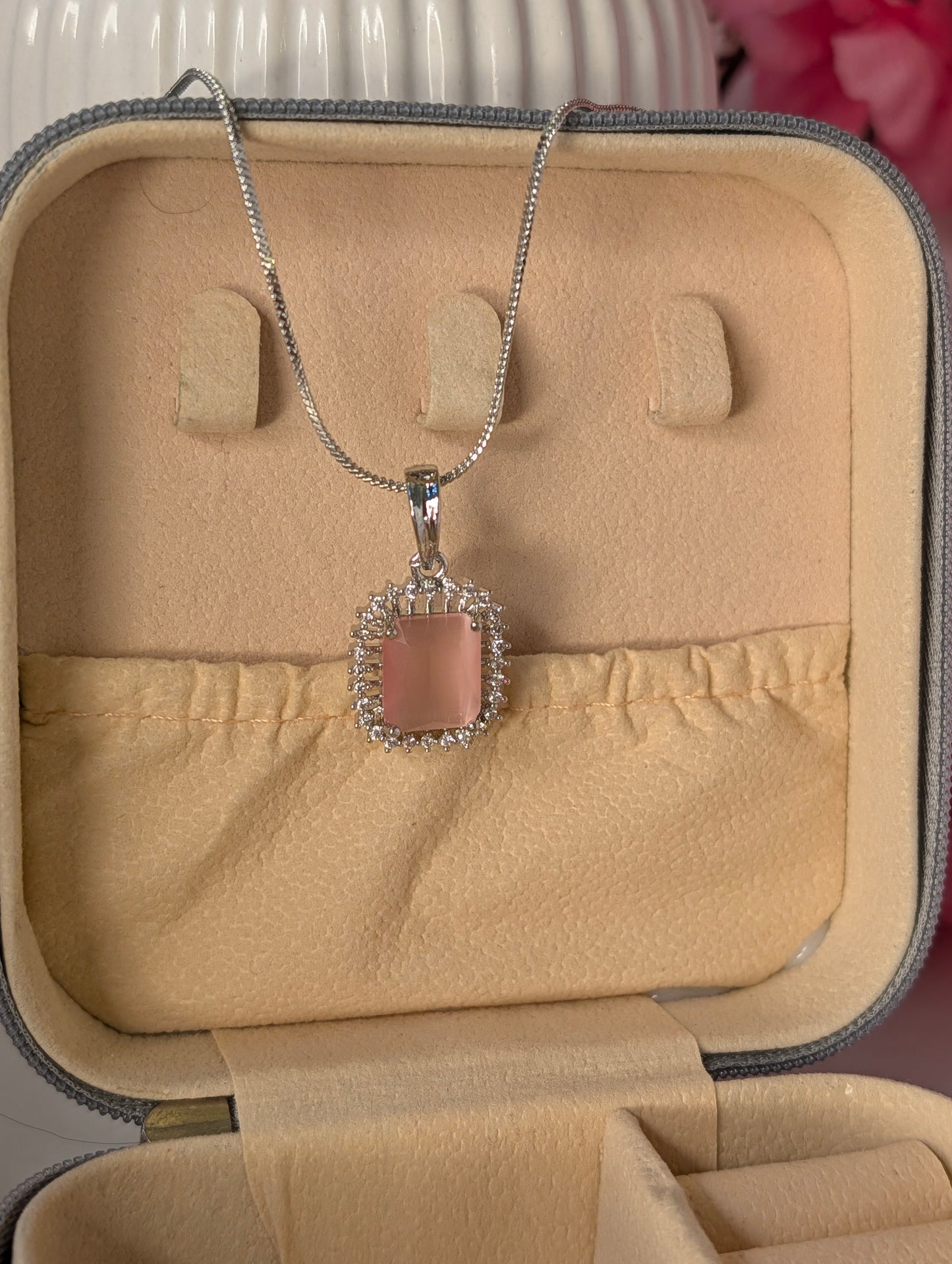 Necklace with a pink pendant in a beige jewelry box