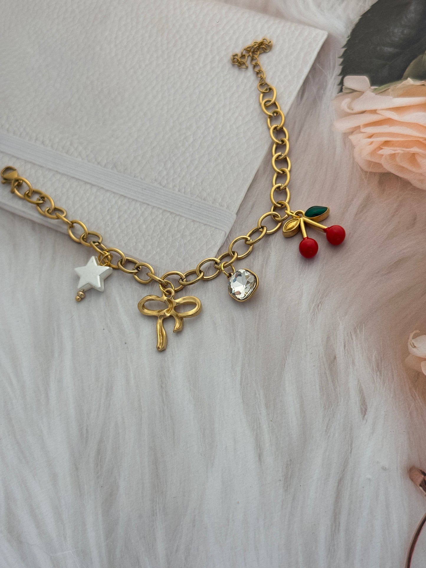 Gold bracelet with charms on a textured surface
