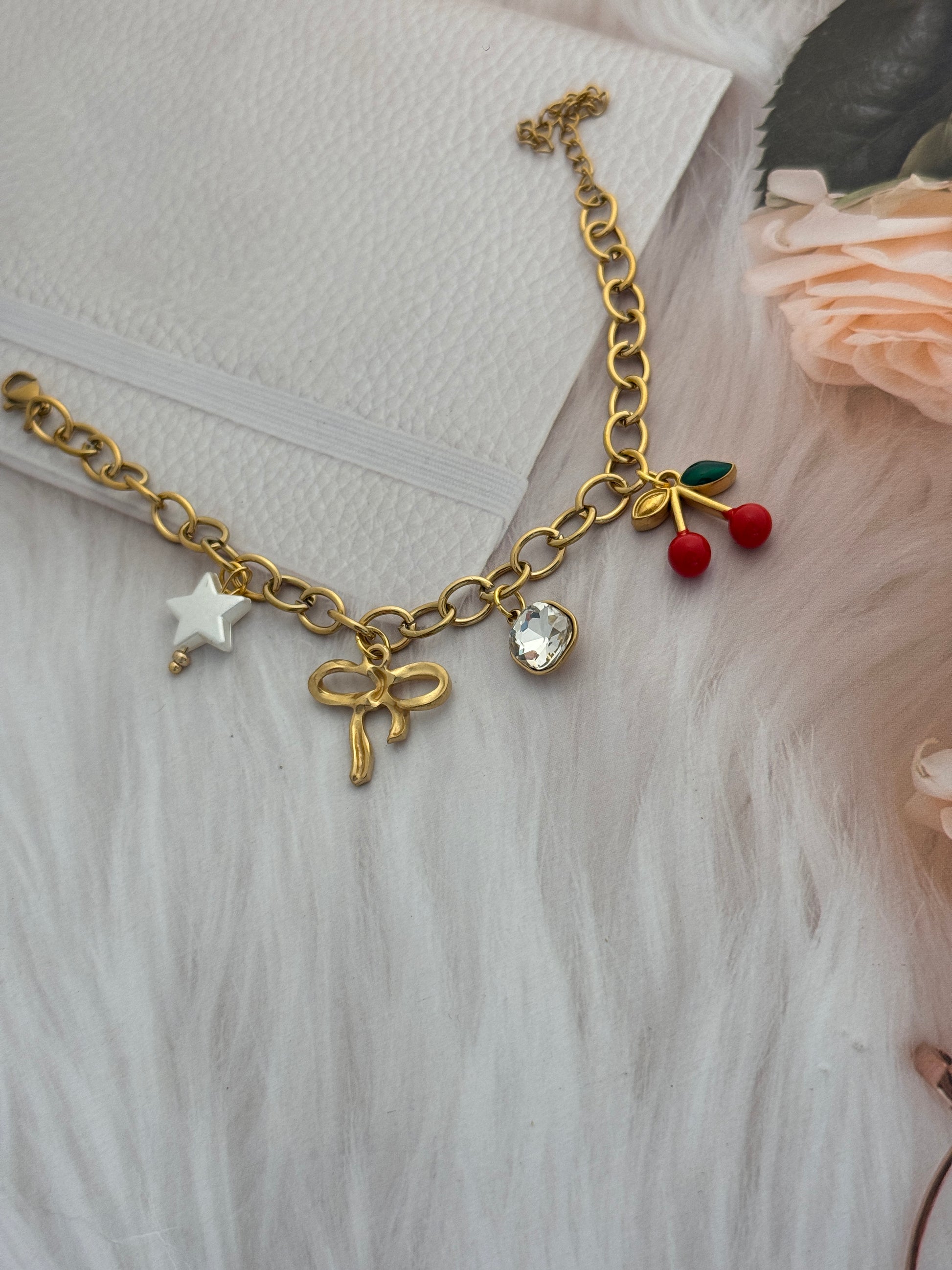 Gold bracelet with charms on a textured surface