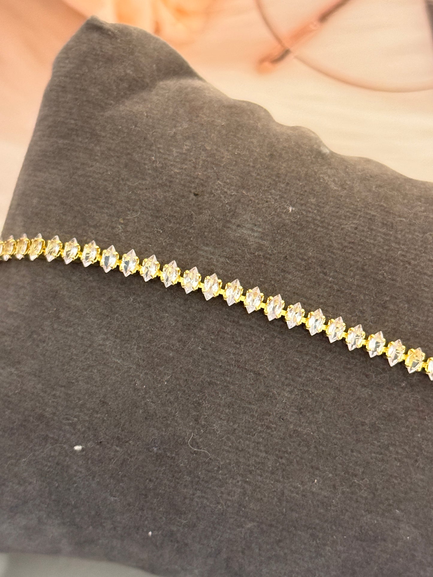 Close-up of a diamond-studded necklace on a dark fabric background