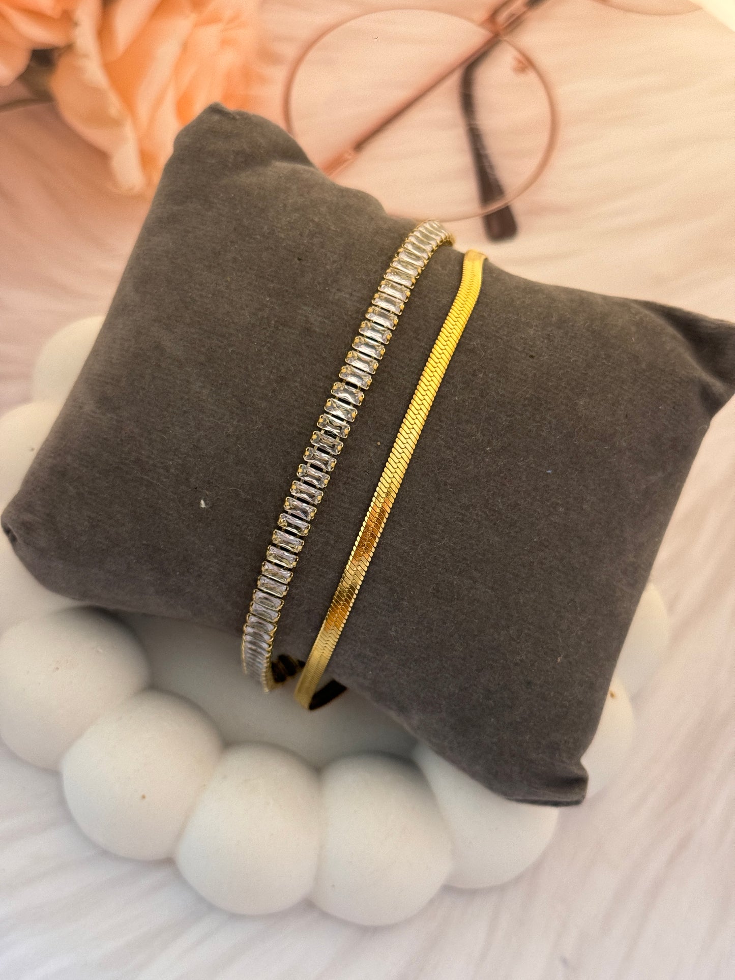 Gray pouch with a gold zipper on a textured surface