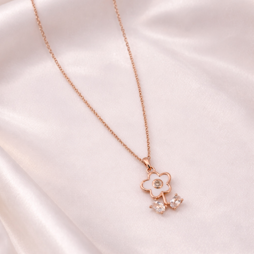 Rose gold necklace with a floral pendant on a satin surface