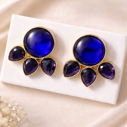 Pair of earrings with blue and purple stones on a white card