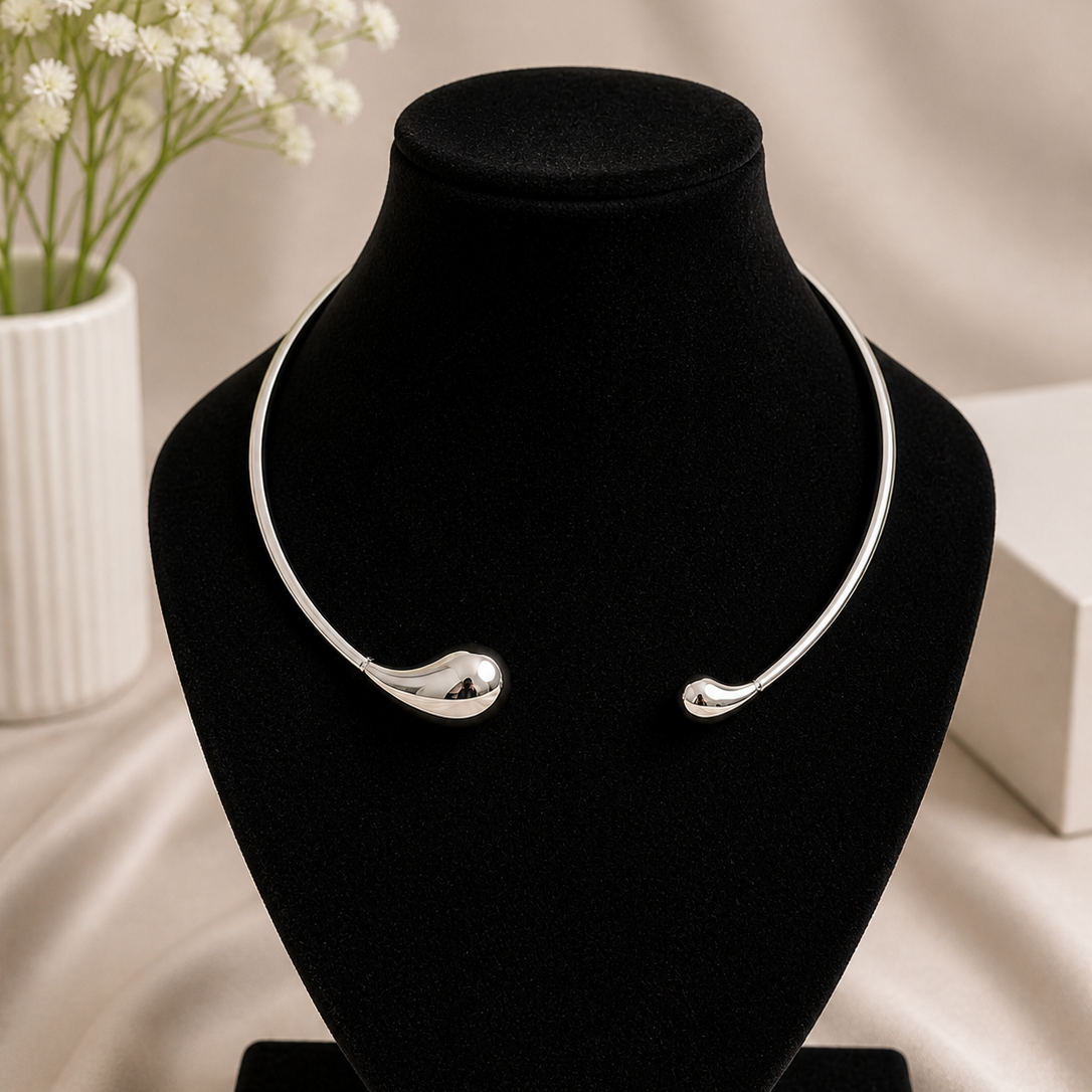 Silver necklace on a black velvet stand with a blurred background