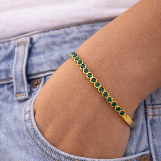 Green beaded anklet on a person's ankle with a denim background