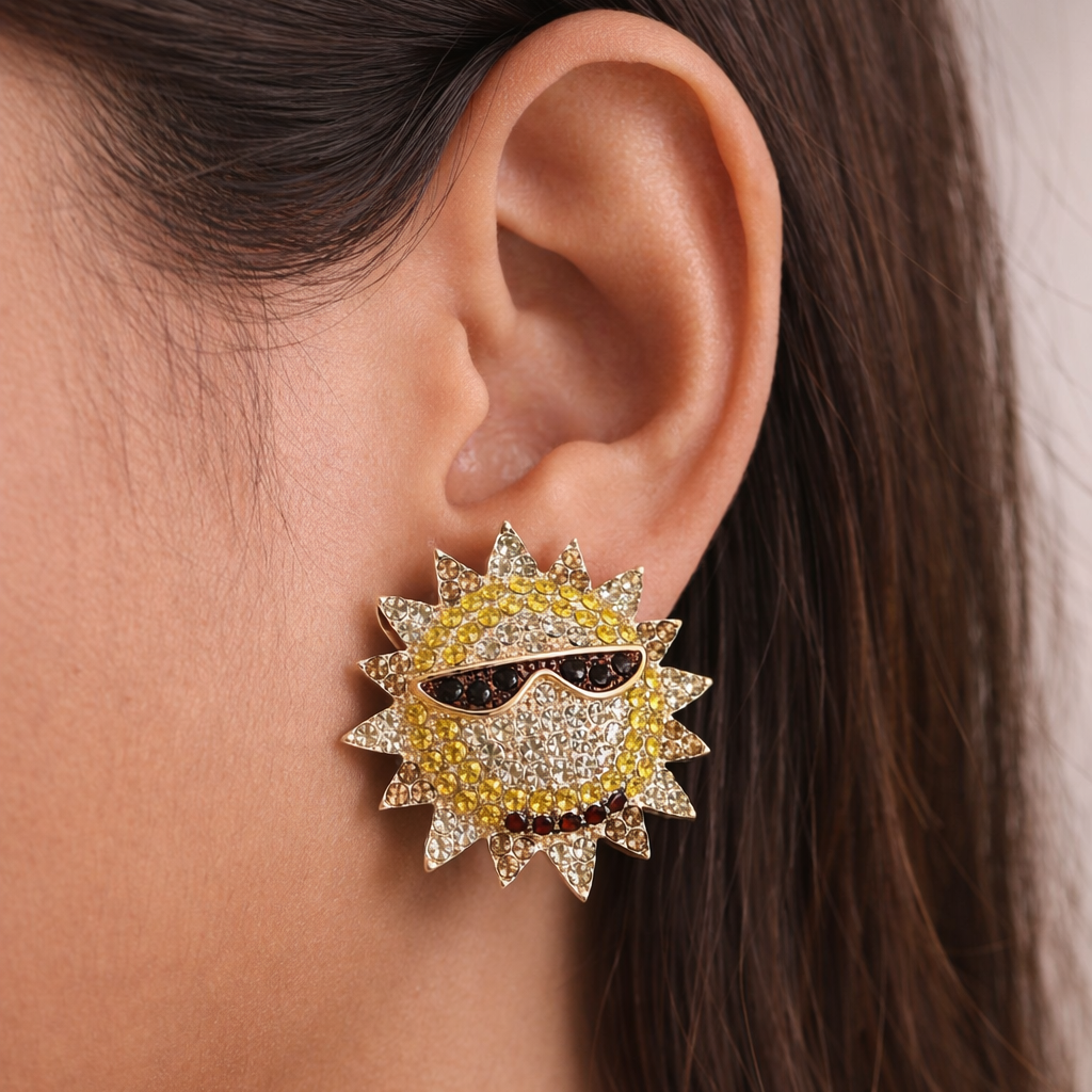 Close-up of a sun-shaped earring with yellow and black details worn by a person.