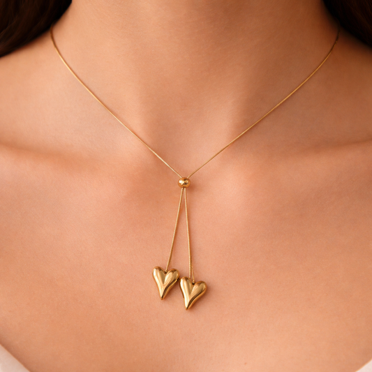 Gold necklace with heart pendants on a person's neck