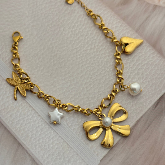 Gold bracelet with charms on a white fabric background