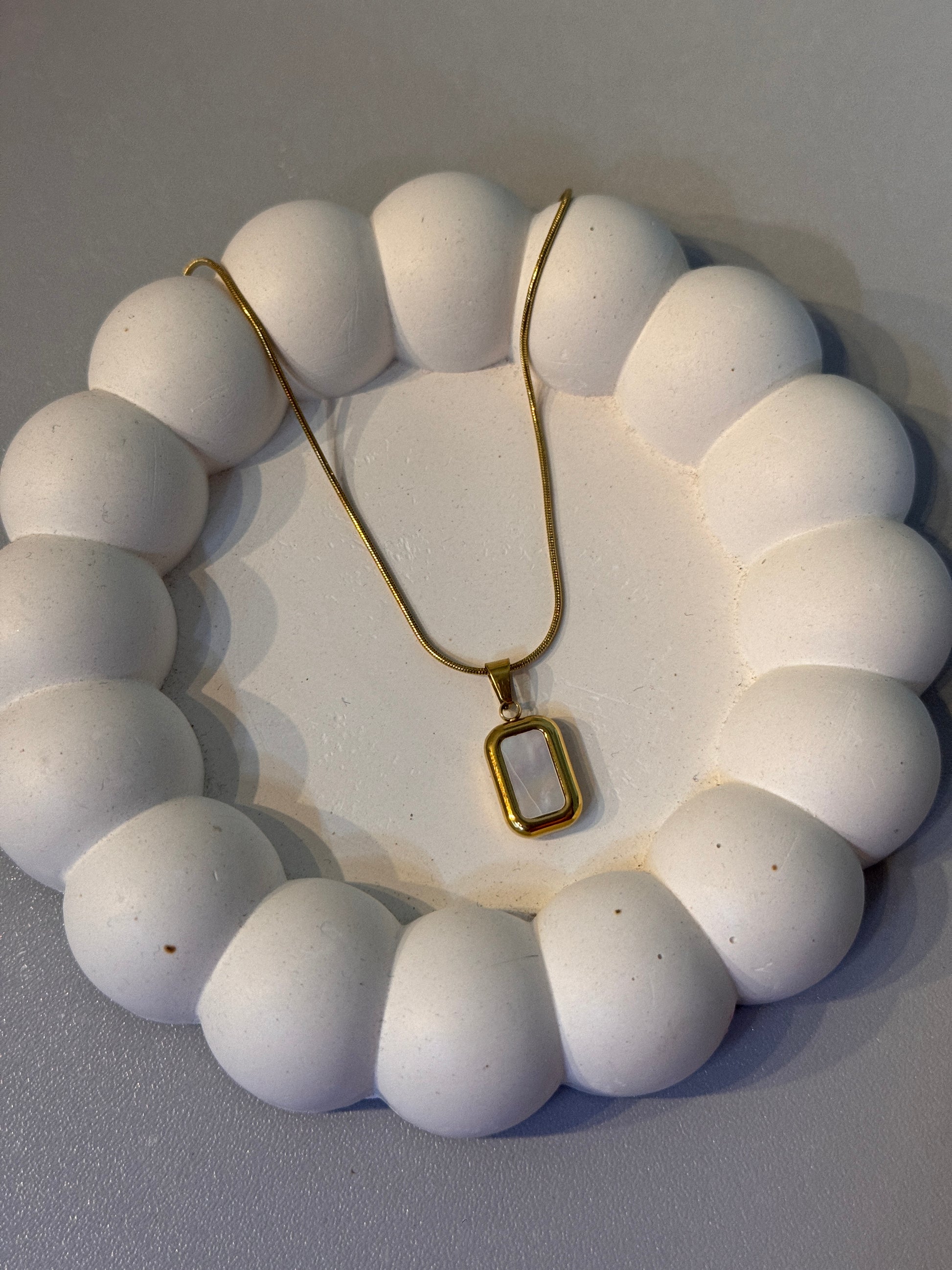 White beaded necklace on a gray background