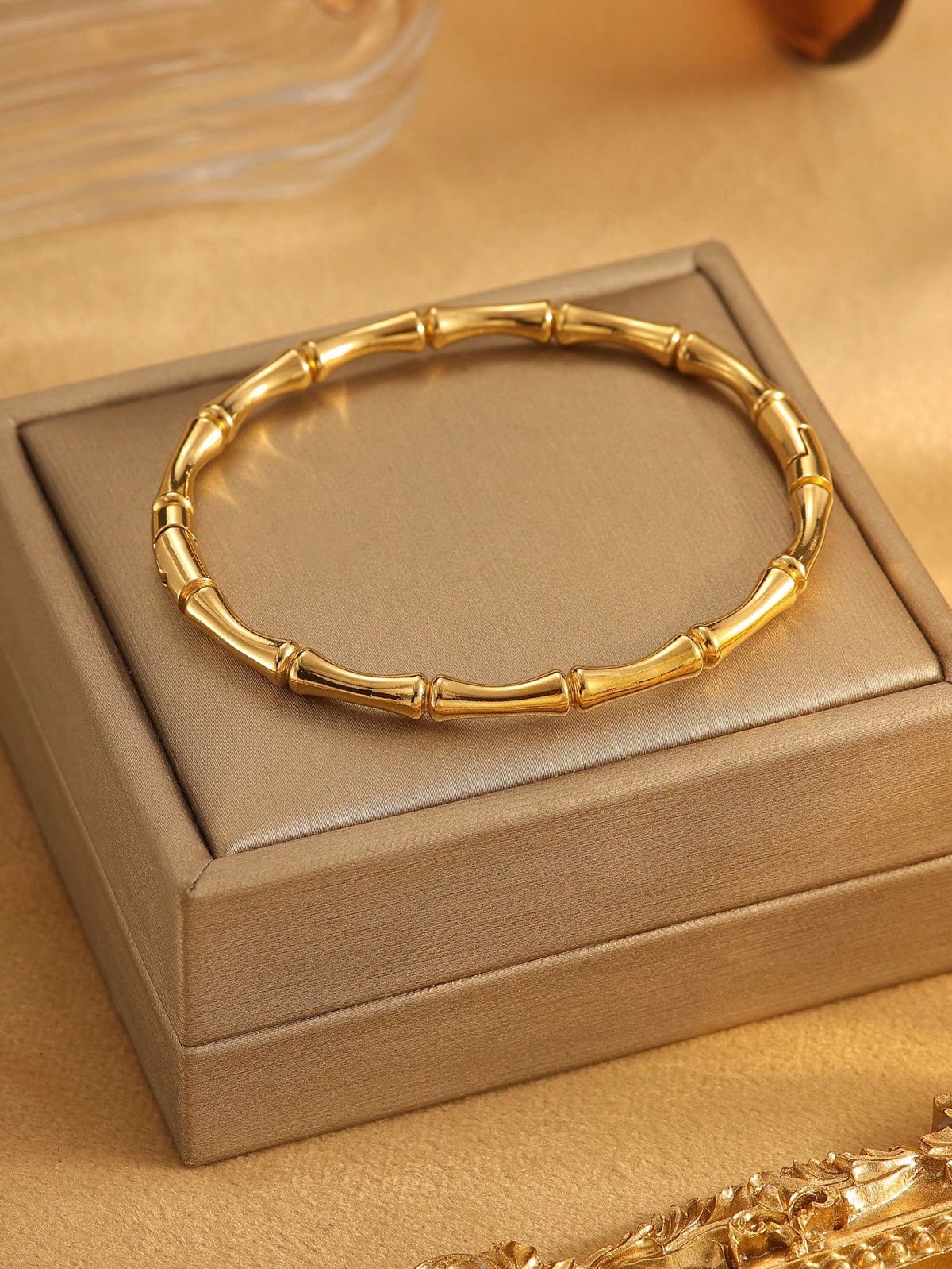 Gold bracelet on a beige jewelry box with a blurred background
