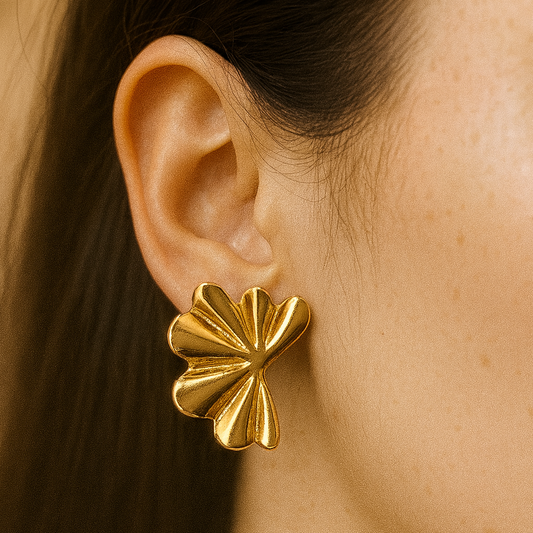 Gold earrings worn by a person with dark hair.
