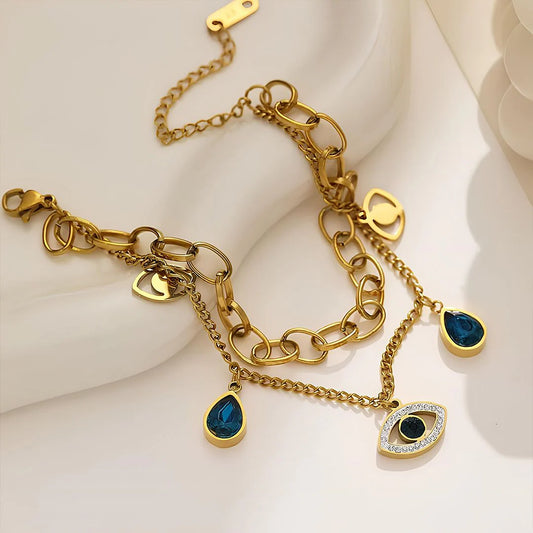 Gold bracelet with blue gemstone charms on a white surface