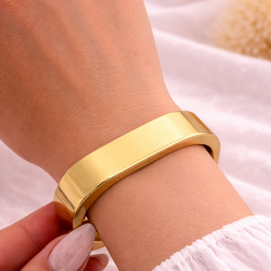 Gold bracelet on a wrist with a soft background