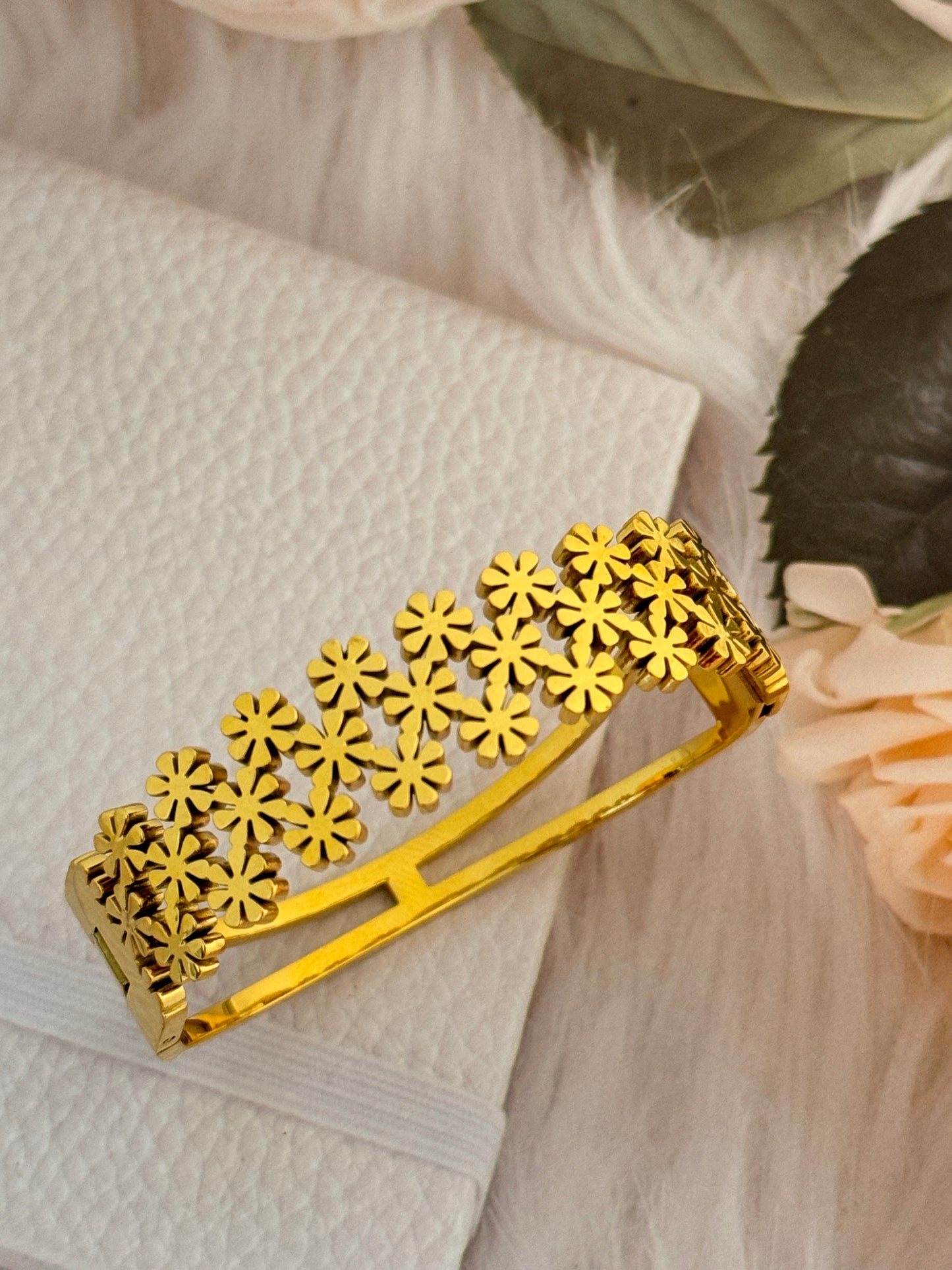 Gold floral design on a white fabric background