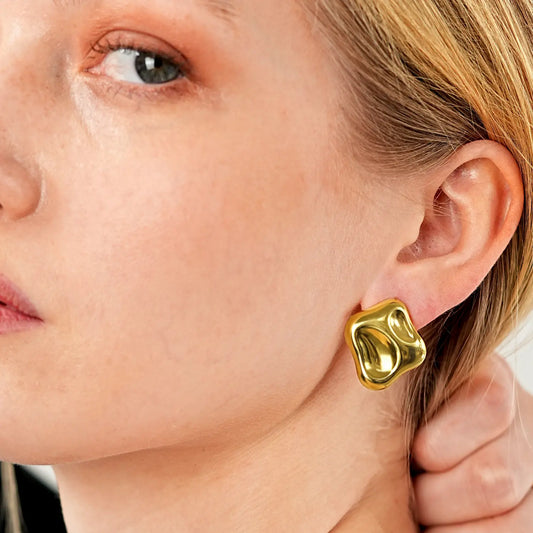 Close-up of a person wearing a gold earring.