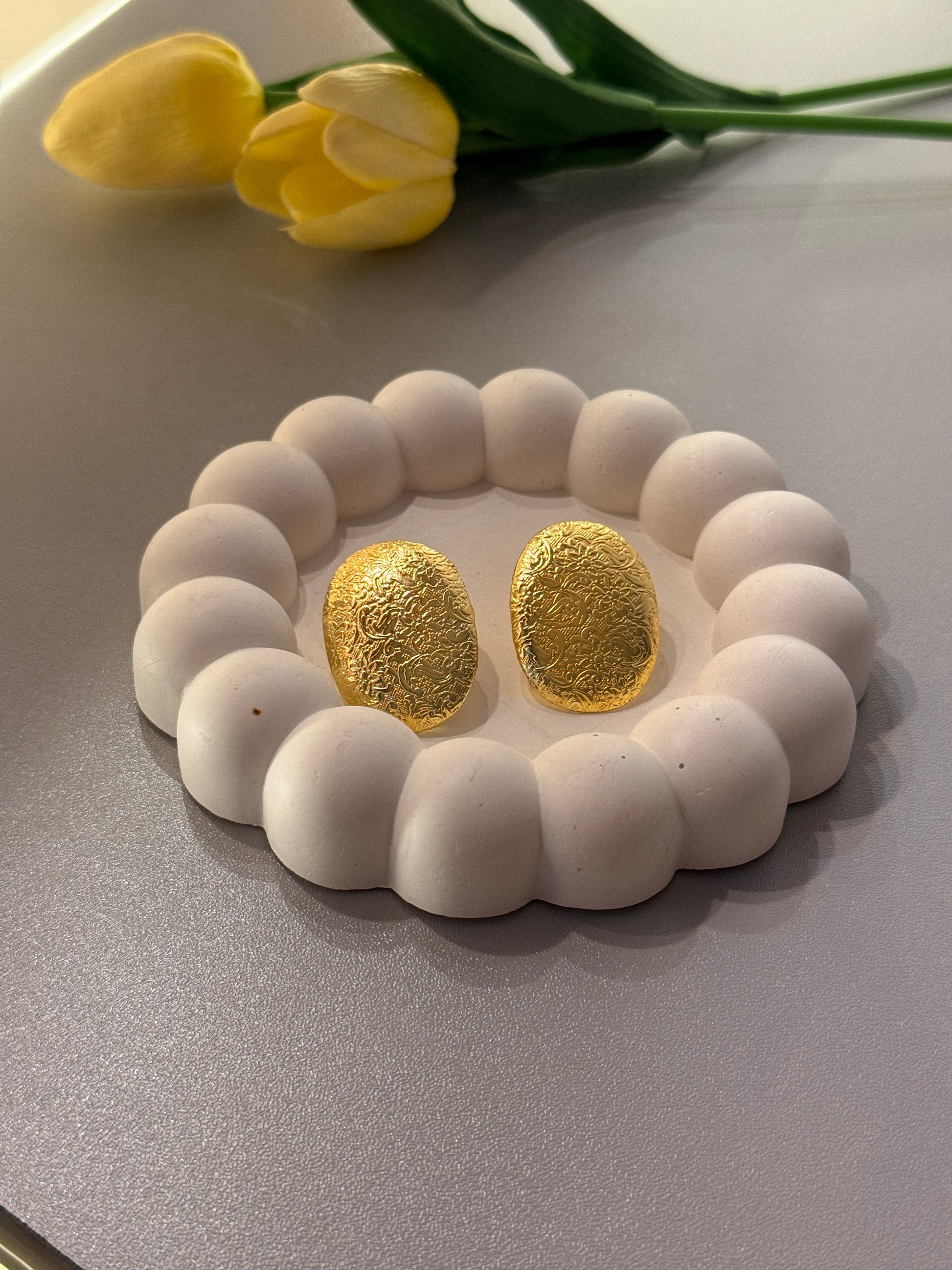 White beaded bracelet with gold stones on a light gray background