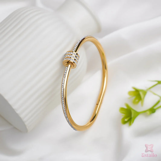 Gold bracelet with diamond accents on a white fabric background