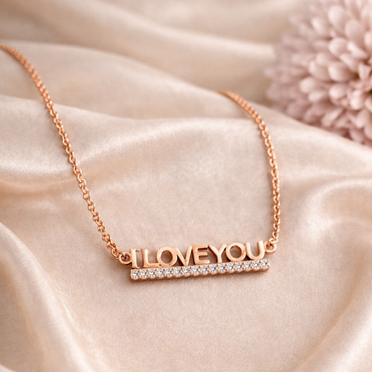 Rose gold necklace with 'I LOVE YOU' pendant on a satin surface