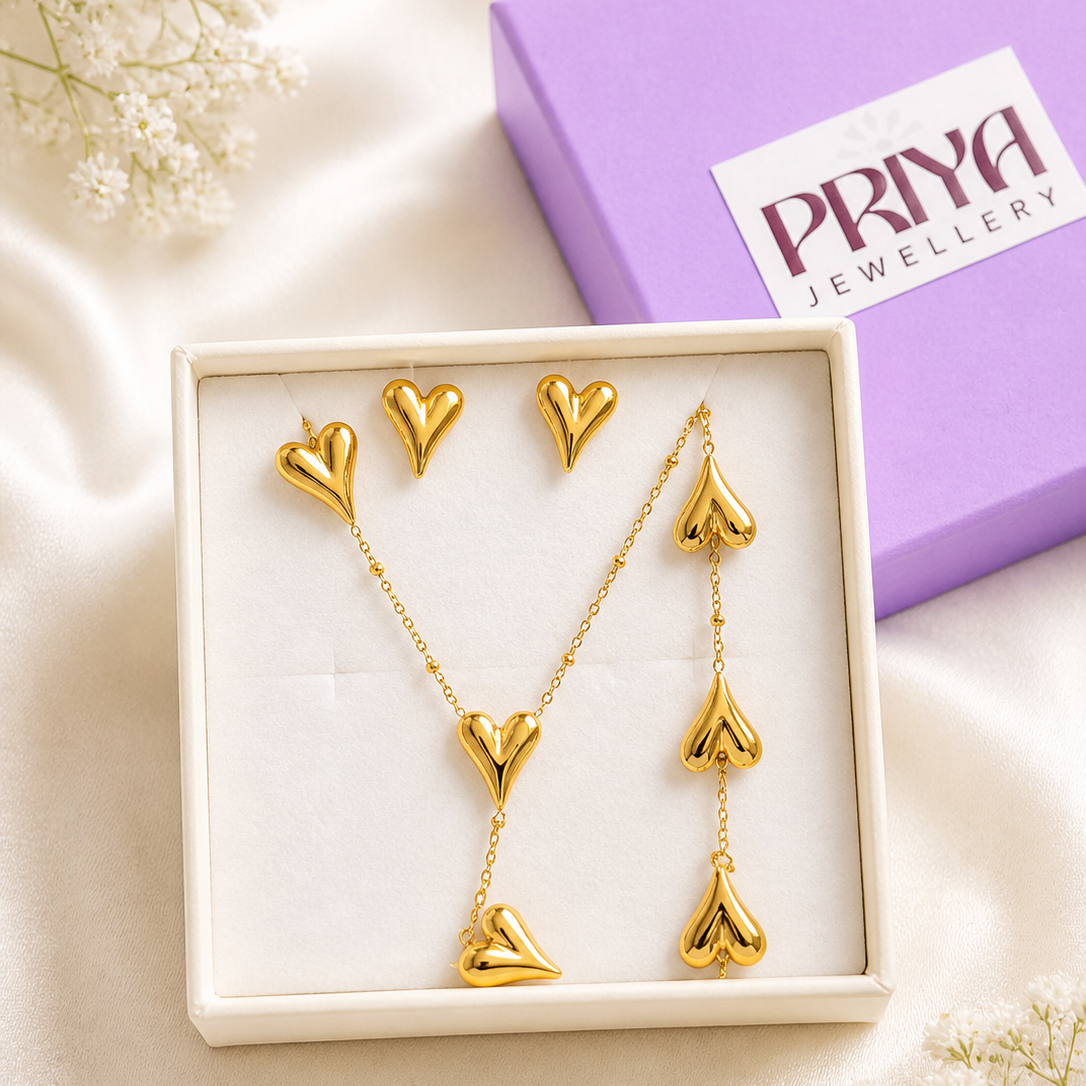 Gold heart-shaped jewelry set in a box with a 'Priya Jewellery' box in the background.
