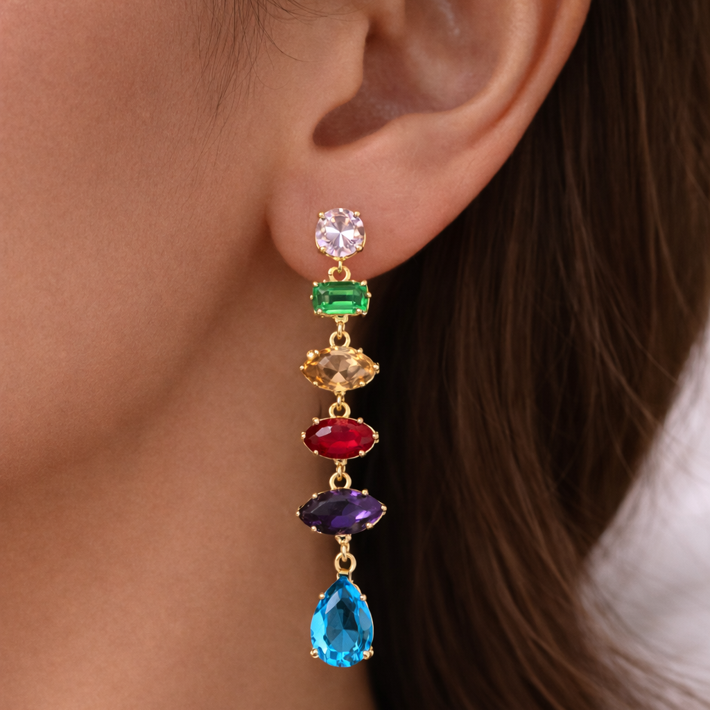 Close-up of colorful gemstone earrings on a person's ear.