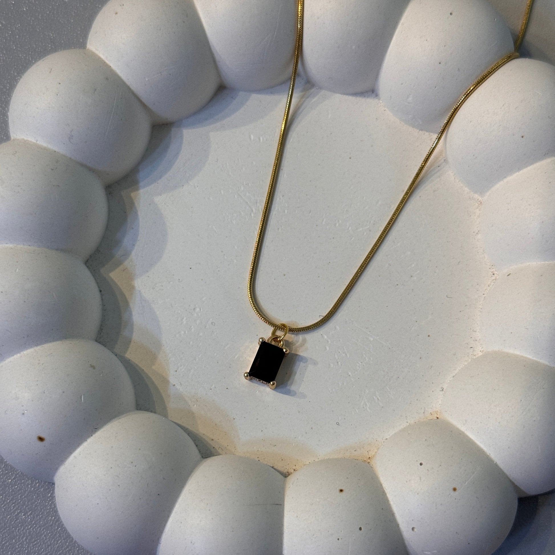 Close-up of a necklace with a diamond on a white background