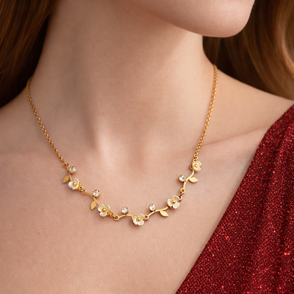 Gold necklace with floral design worn by a person in a red garment