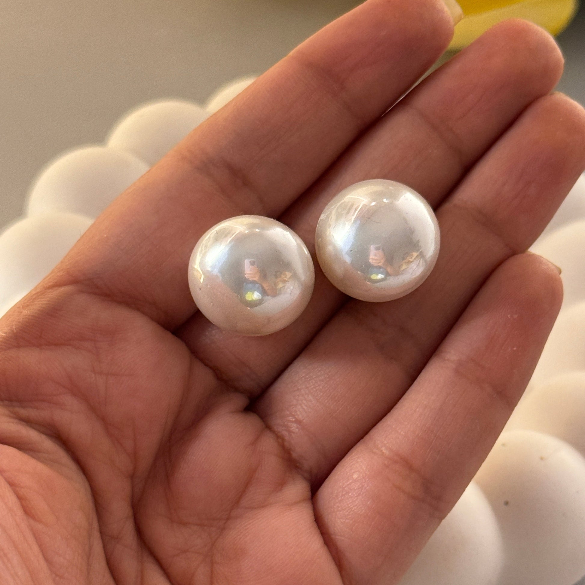 Two pearls held in a hand with a blurred background