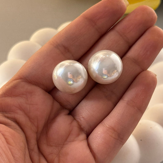 Two pearls held in a hand with a blurred background