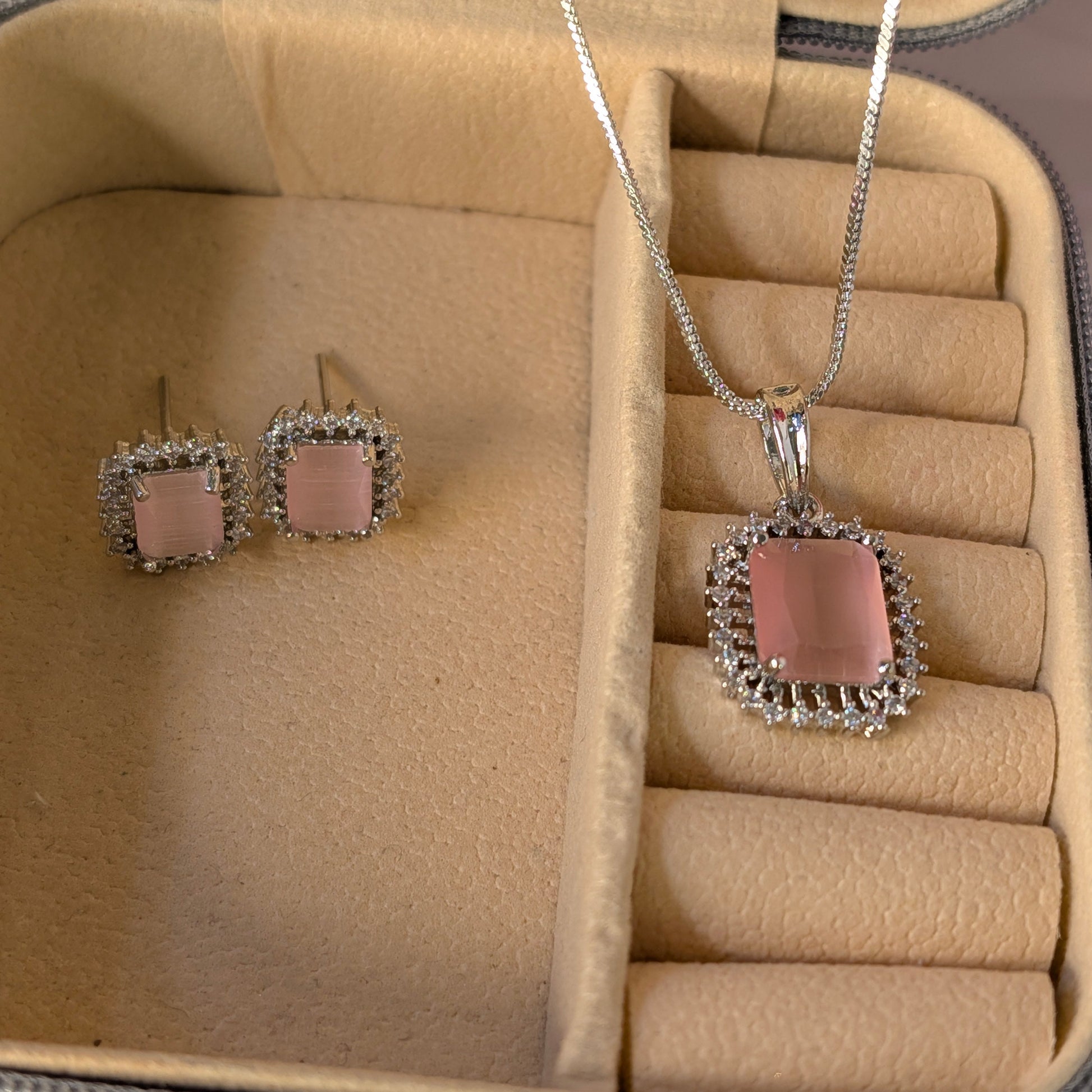 Jewelry set with pink pendant and earrings in a beige jewelry box